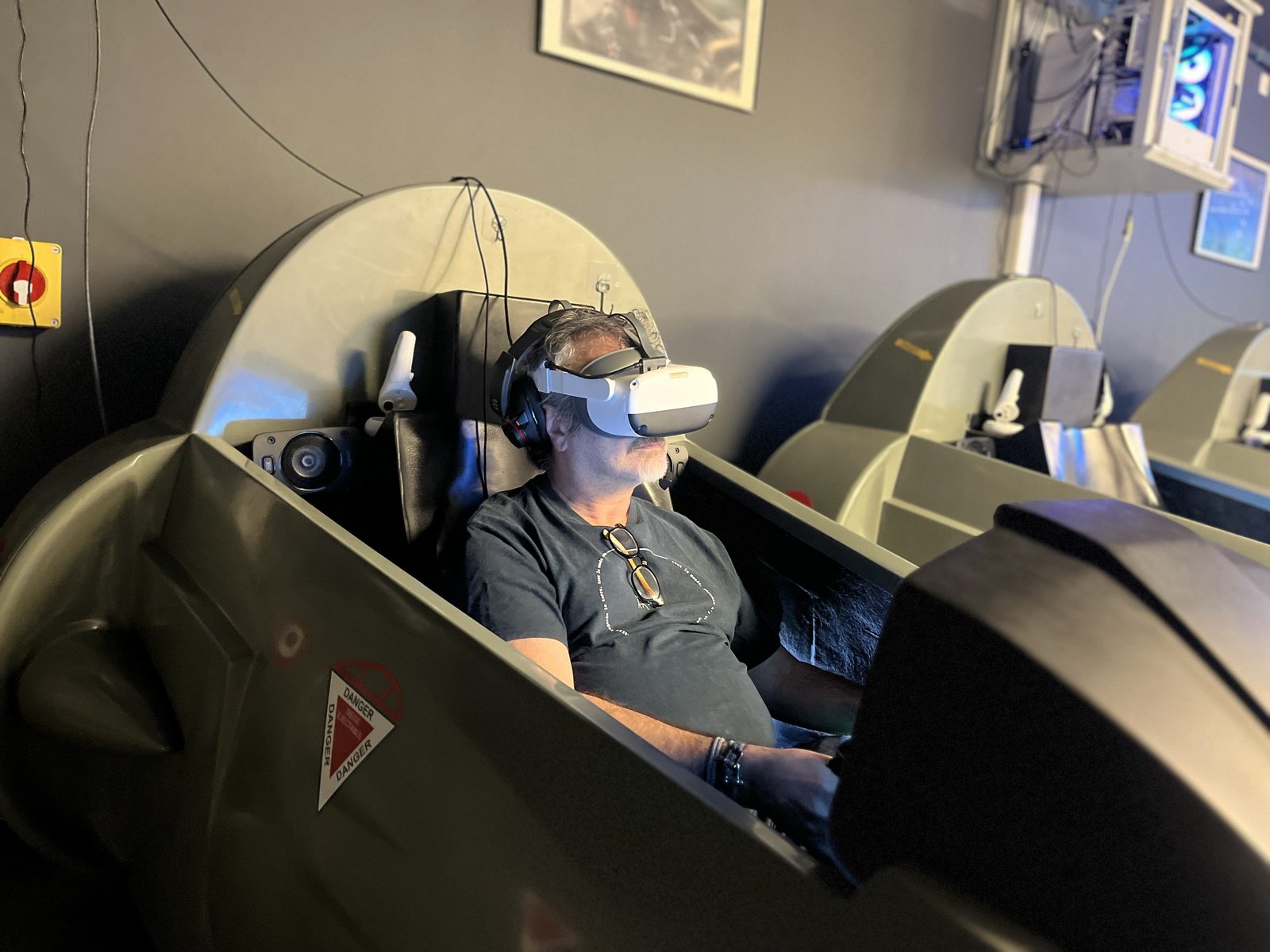 Un pilote aux commandes du simulateur Mirage 2000, casque de réalité virtuelle sur la tête